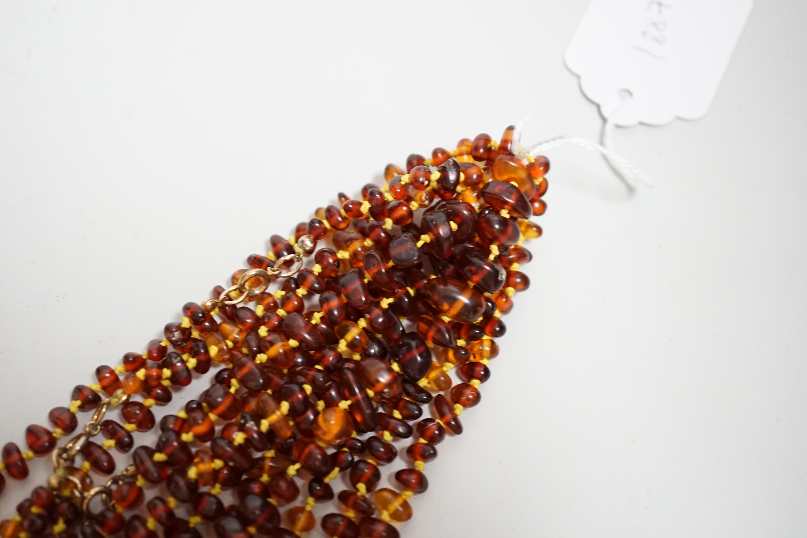 Five assorted single strand amber bead necklaces.